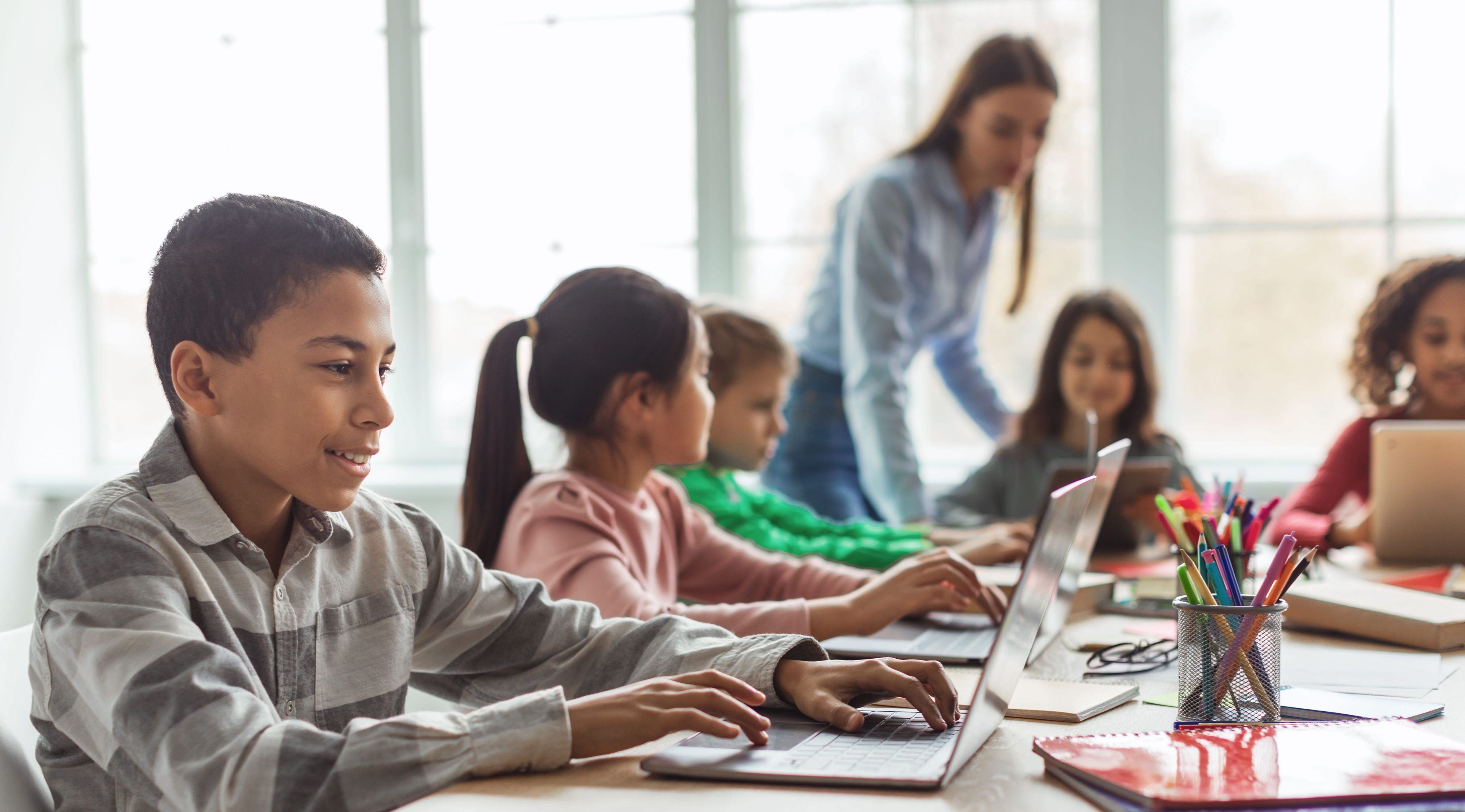 Children in a classroom using laptop computers