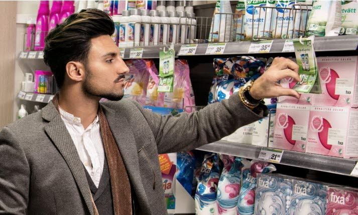 Man shopping in a store looking at grocery shelf