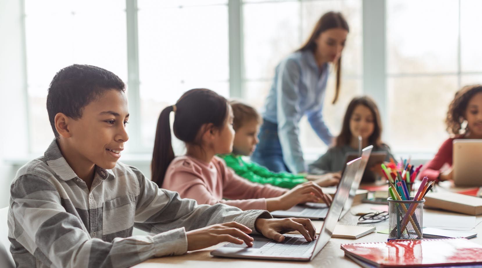 Children in a classroom using laptop computers