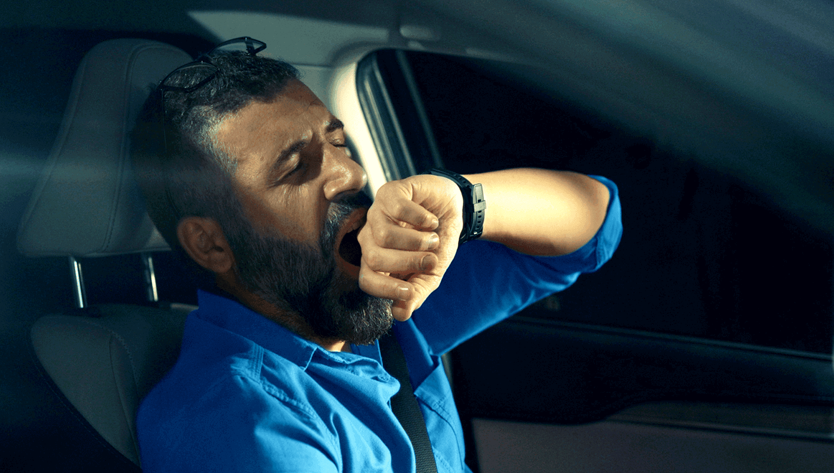 Man yawning in the car