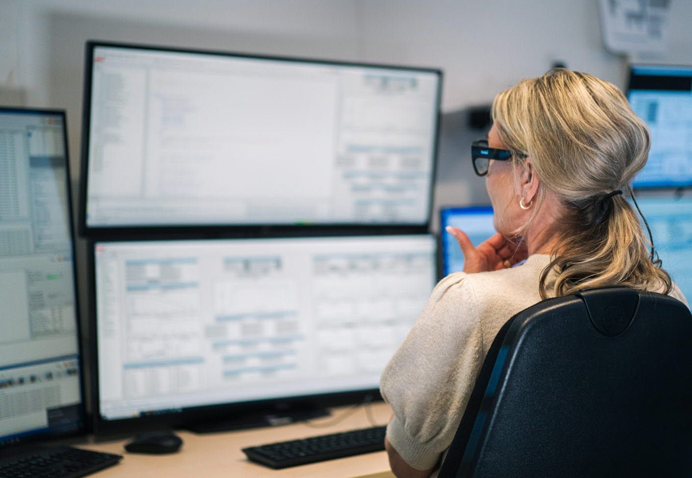 Woman wearing Tobii Pro Glasses 3 looking at screens